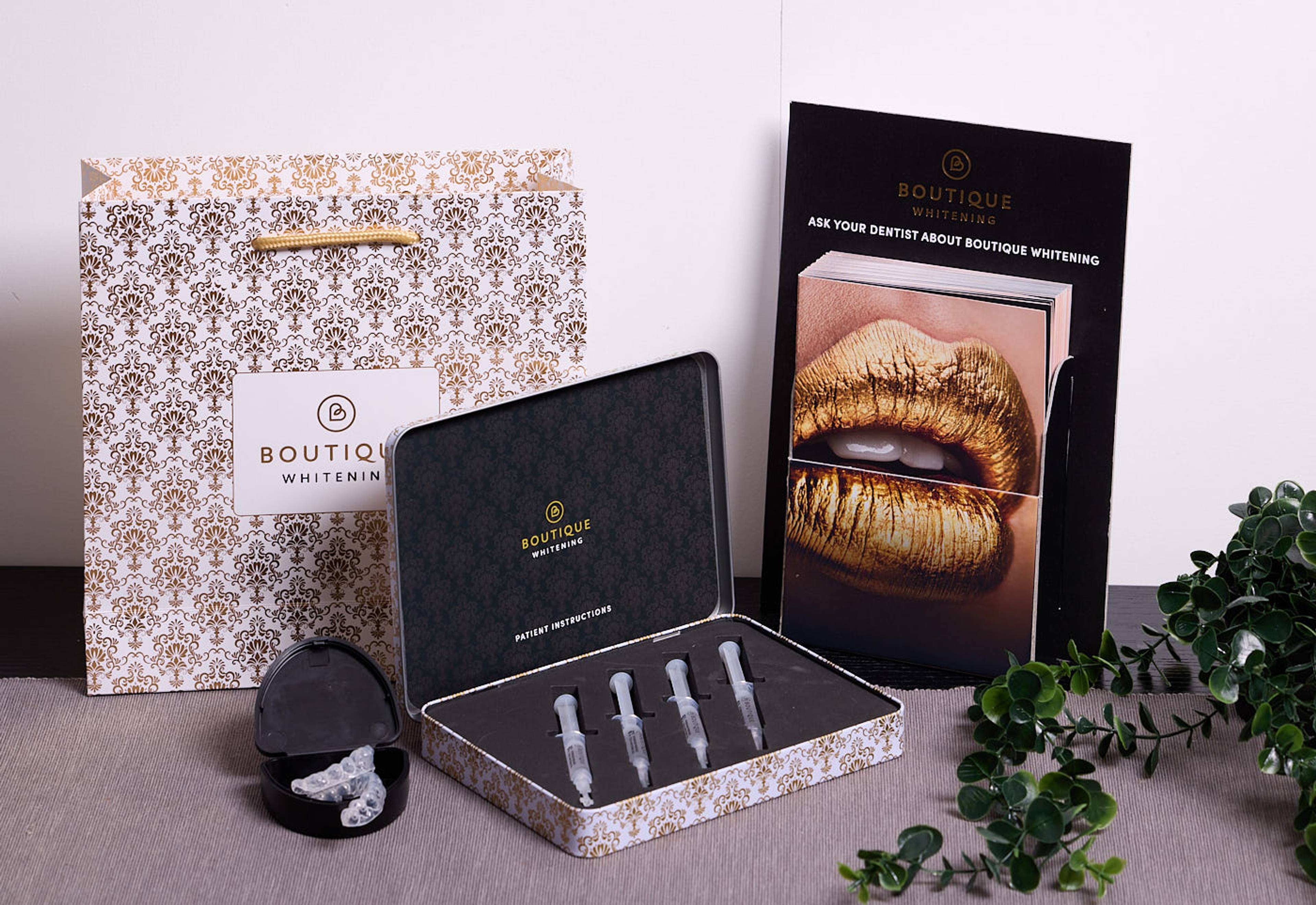 Professional teeth whitening kit with whitening gel syringes, whitening trays, and Boutique Whitening branded packaging.