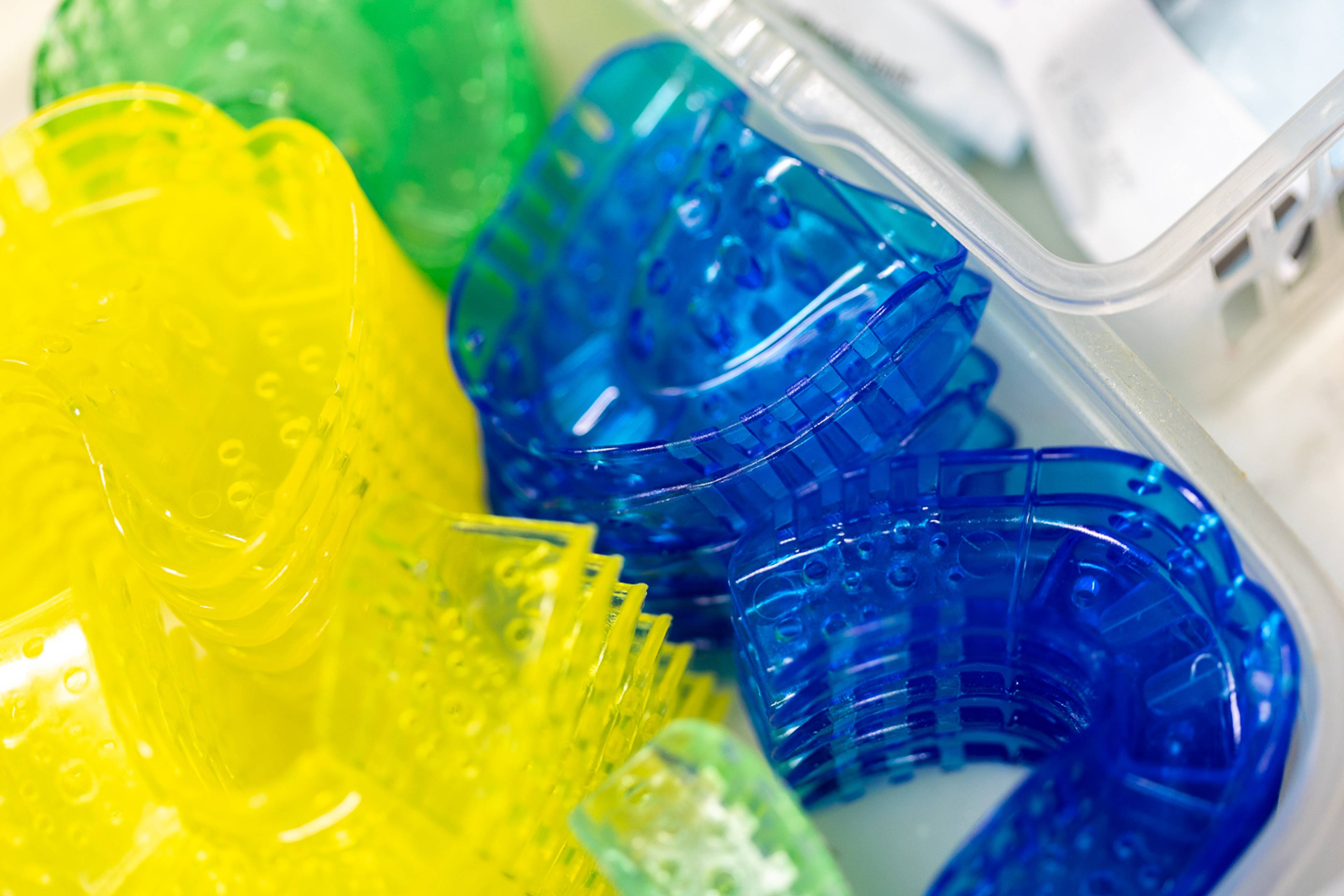 Colorful dental impression trays stored in a container, ready for use during dental procedures.