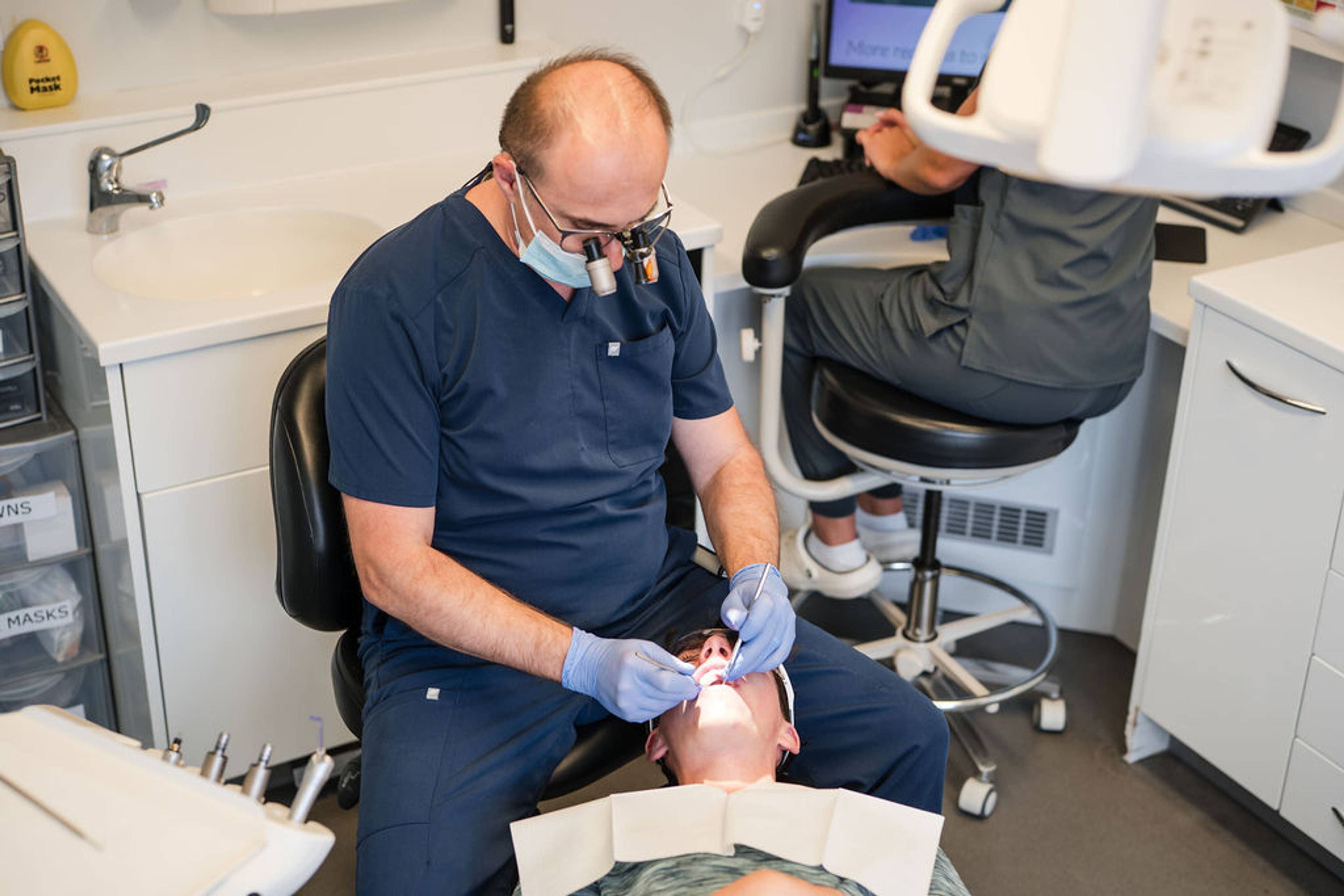 Dentist performing advanced general dentistry treatment using magnification loupes and modern dental technology to provide high-quality patient care at Pontesbury Dental.