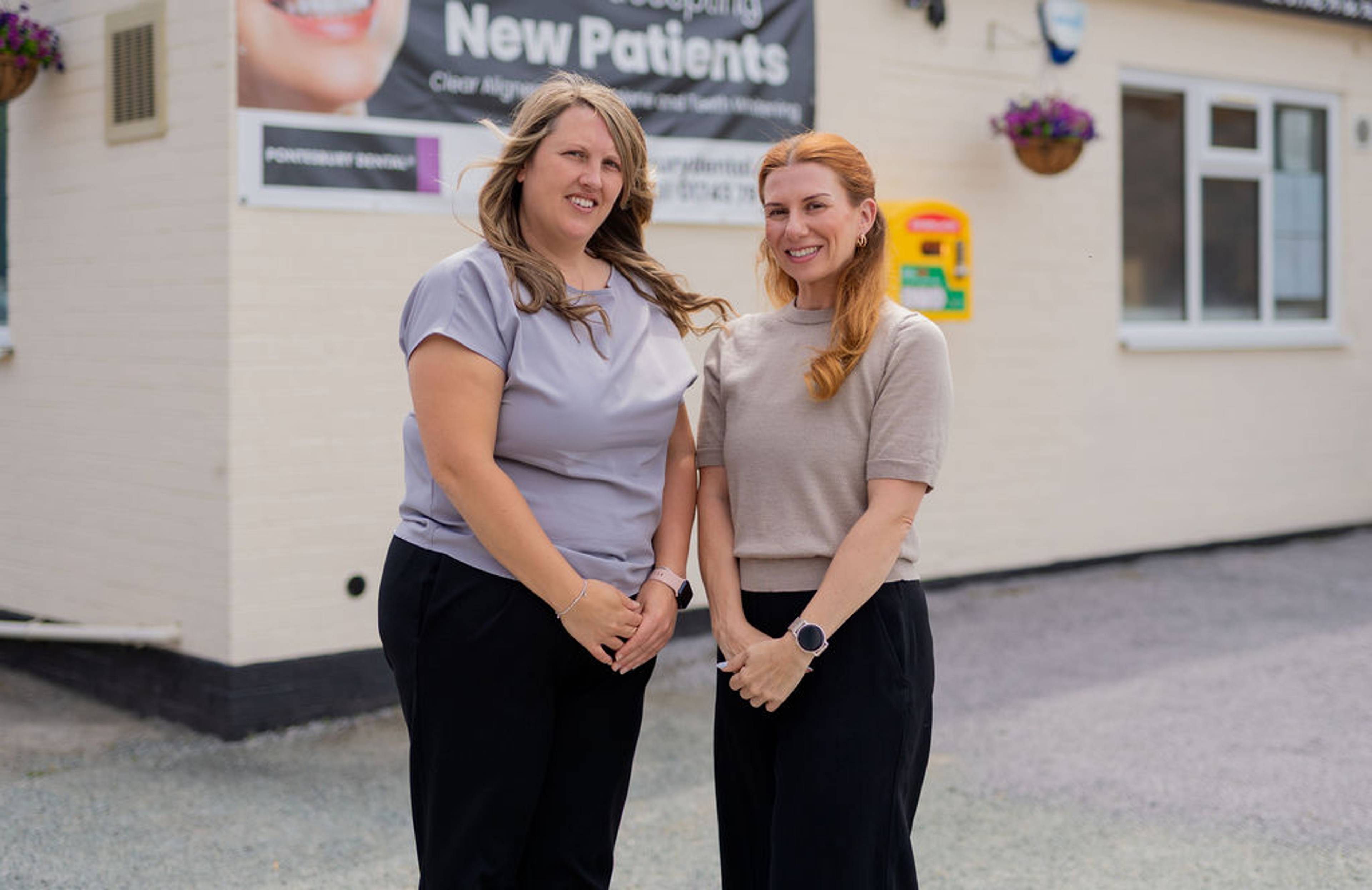 Pontesbury Dental team standing outside the clinic building for a group photo in front of signage welcoming new patients.