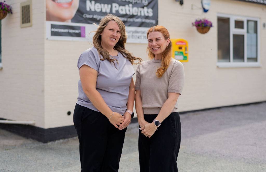 Pontesbury Dental team standing outside the clinic building for a group photo in front of signage welcoming new patients.