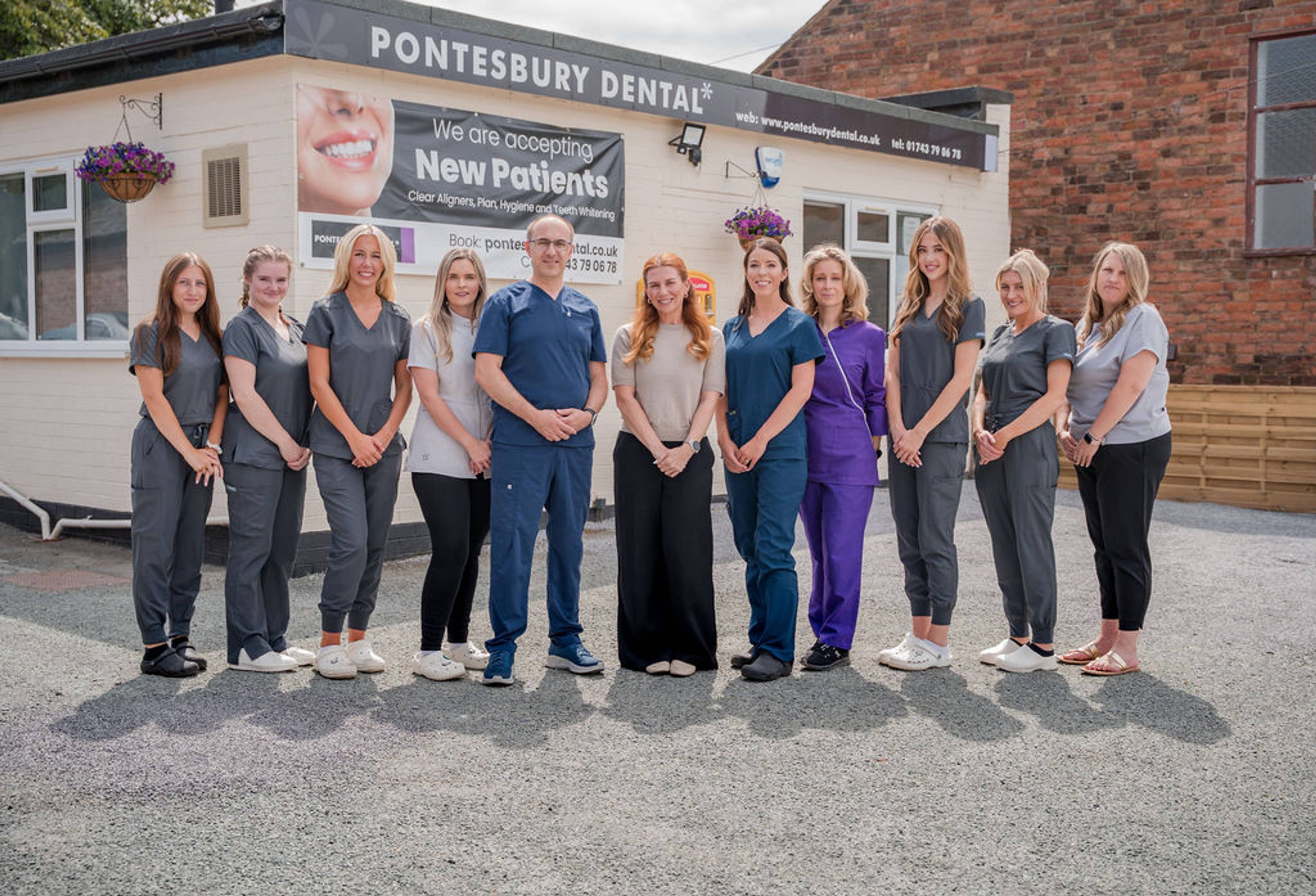Close-up of Pontesbury Dental exterior signage promoting new patient registrations, clear aligners, hygiene services, and teeth whitening treatments.