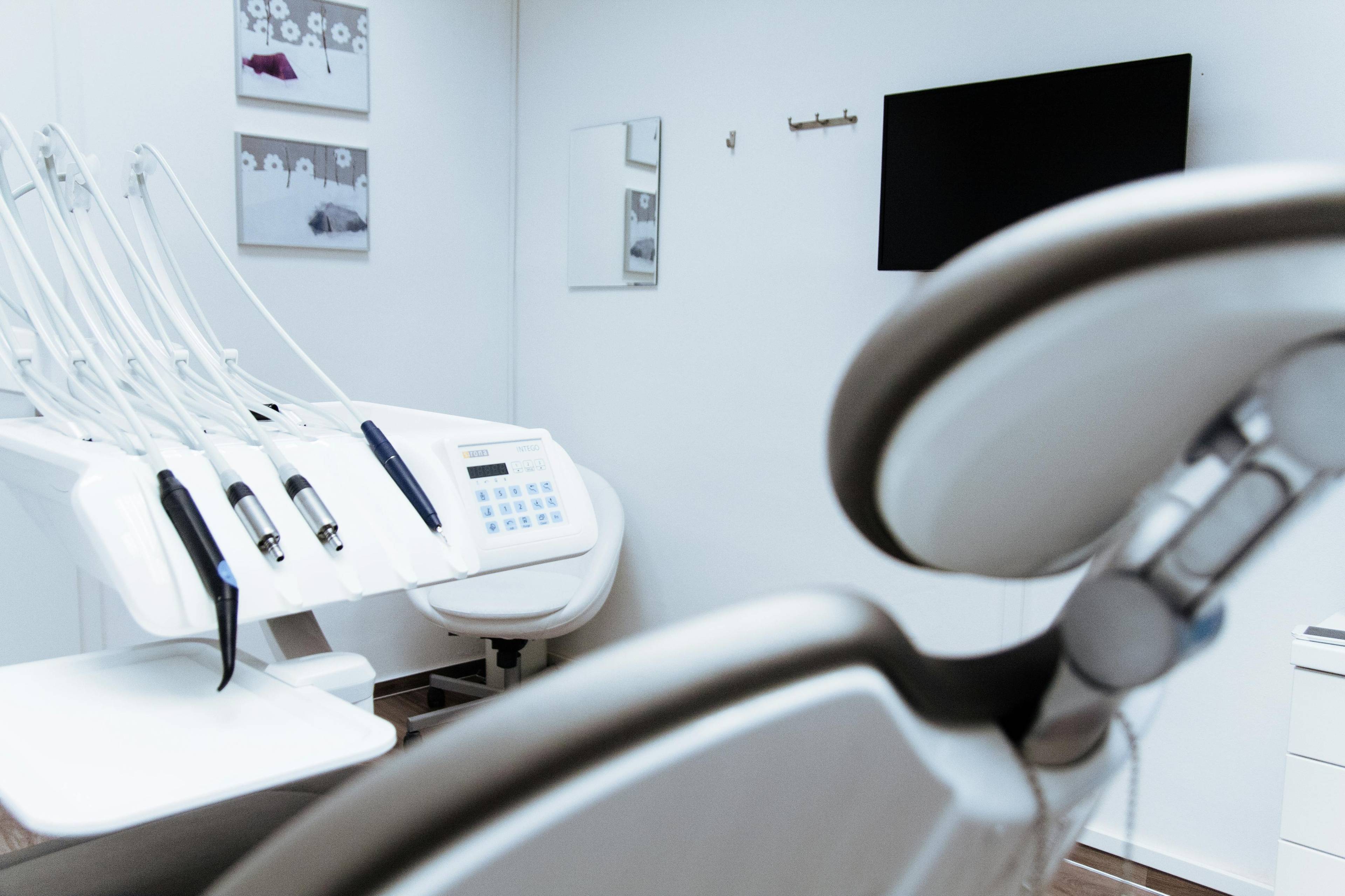 Modern dental treatment unit with an overhead examination light, dental handpieces, and sterile instruments prepared for patient care.