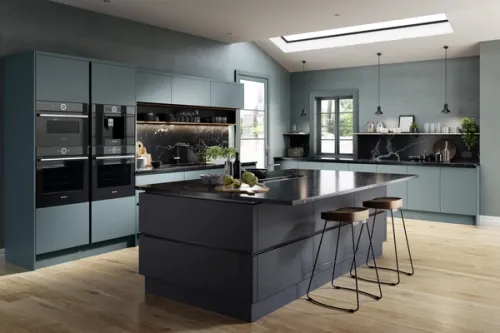 A vibrant modern handless kitchen featuring a large central island breakfast bar