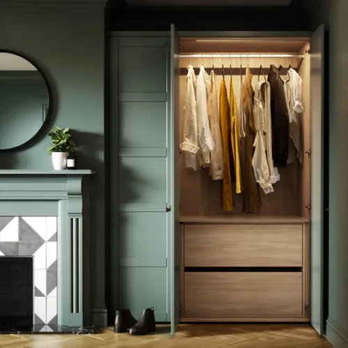 An open wardrobe with neatly organized clothes displayed above two wood finished closed internal drawers, highlighting the perfect blend of functionality and aesthetics