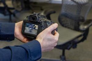 Photo of a camera recording video of a Herman Miller chair for use in the Gaussian Splatting process