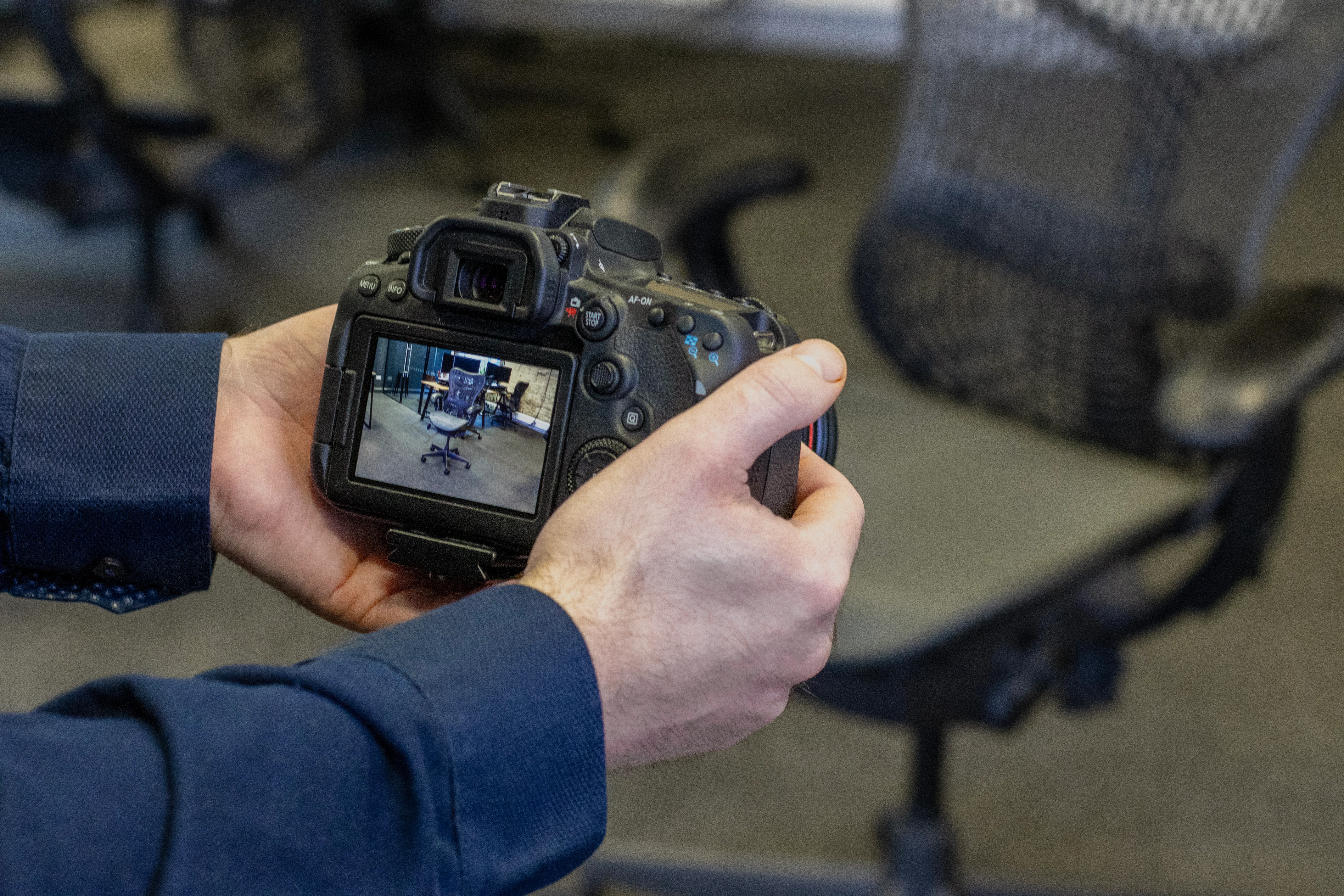 Photo of a camera recording video of a Herman Miller chair for use in the Gaussian Splatting process