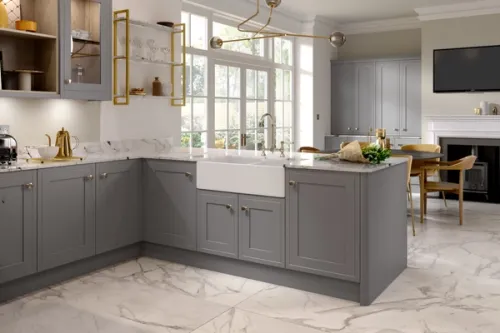 Ceramic Belfast style sink in a Shaker style kitchen with gold accessories