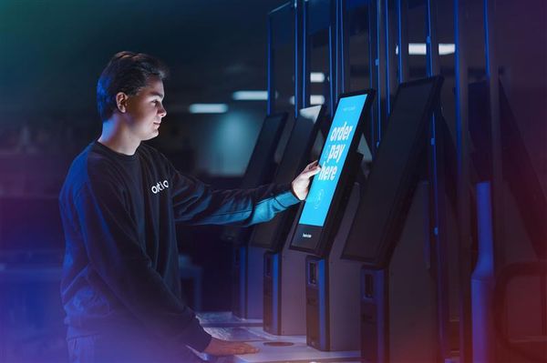 a young man is using a kiosk in a dark room .