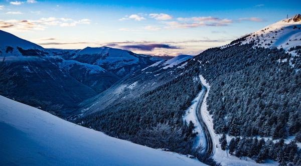 Malerisk vinterlandskap med en vei, som fanger den fredelige skjønnheten til et snødekket miljø og en sti gjennom naturen.