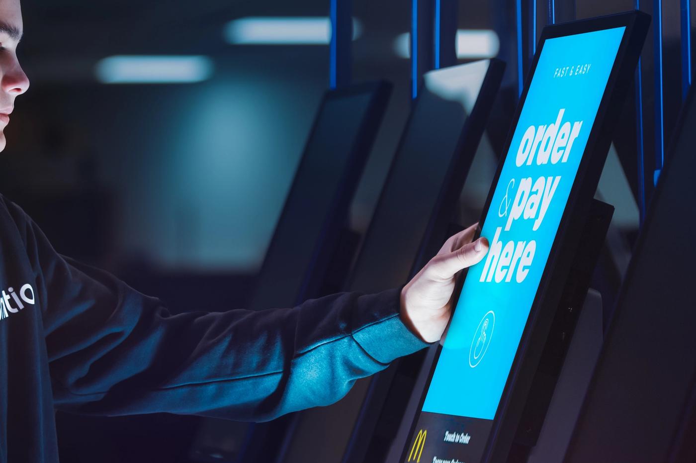 a young man is using a kiosk in a dark room .