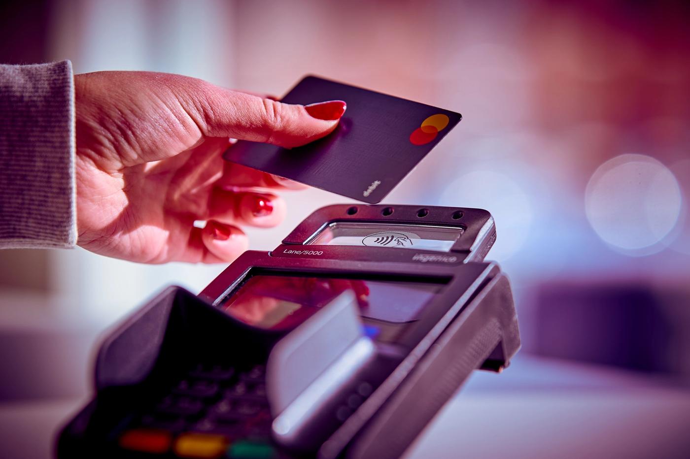 a woman is paying with a credit card on a credit card machine .