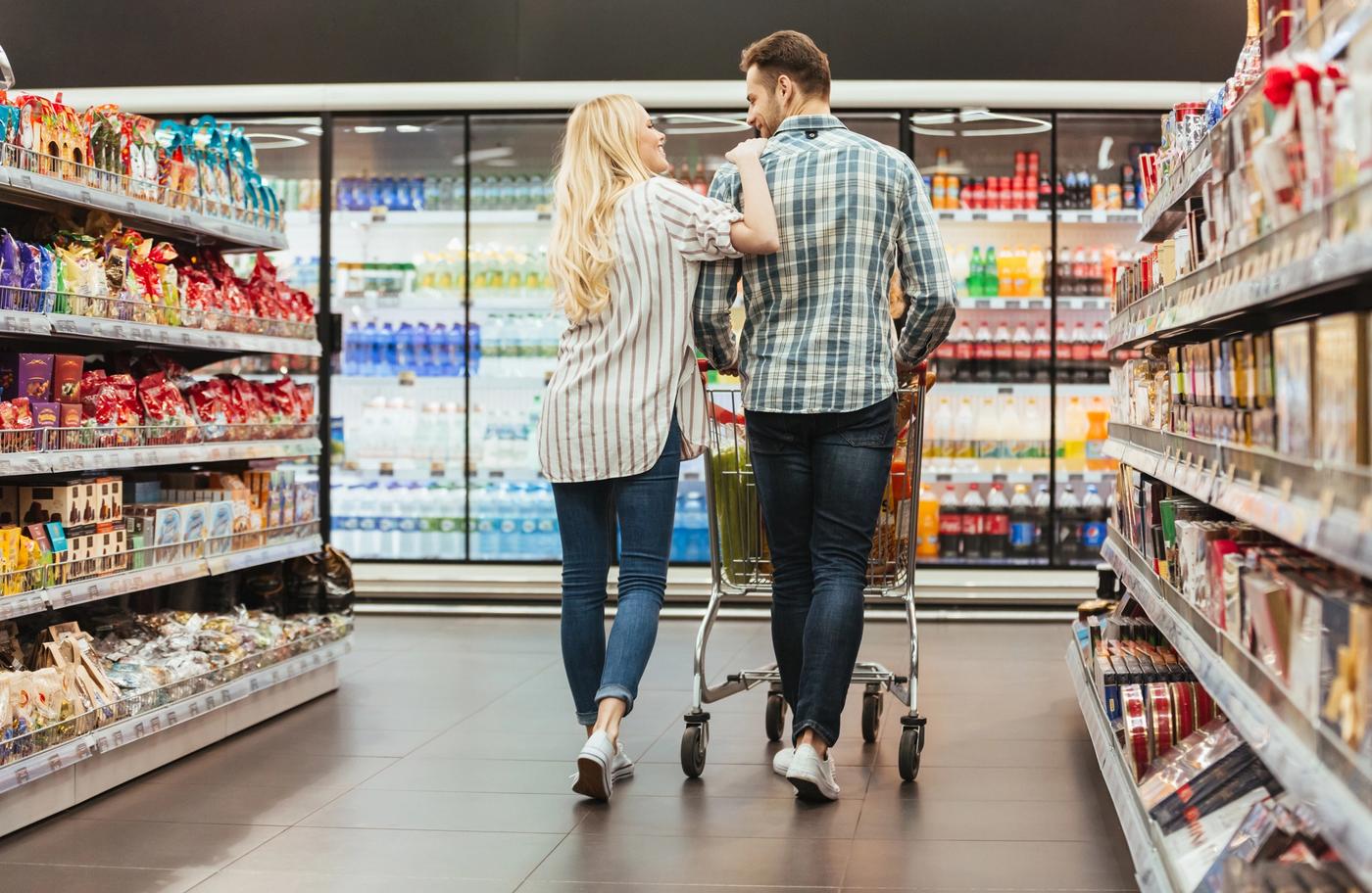 Couple walking down an aisle at a grocery store