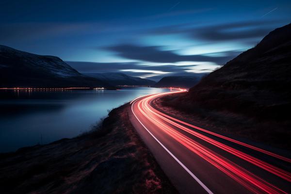 Scenic nature view with a horizon, featuring a road illuminated by the lights of passing cars, capturing the beauty of the journey through the landscape.