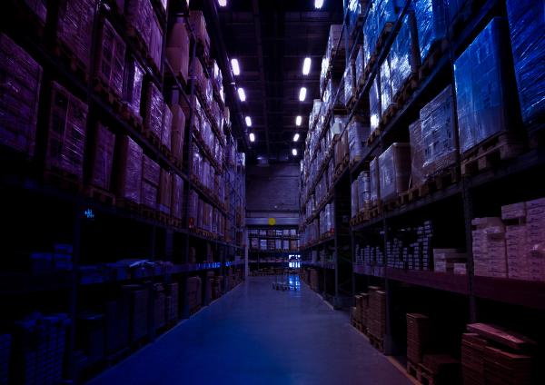 a warehouse filled with lots of boxes and shelves at night .