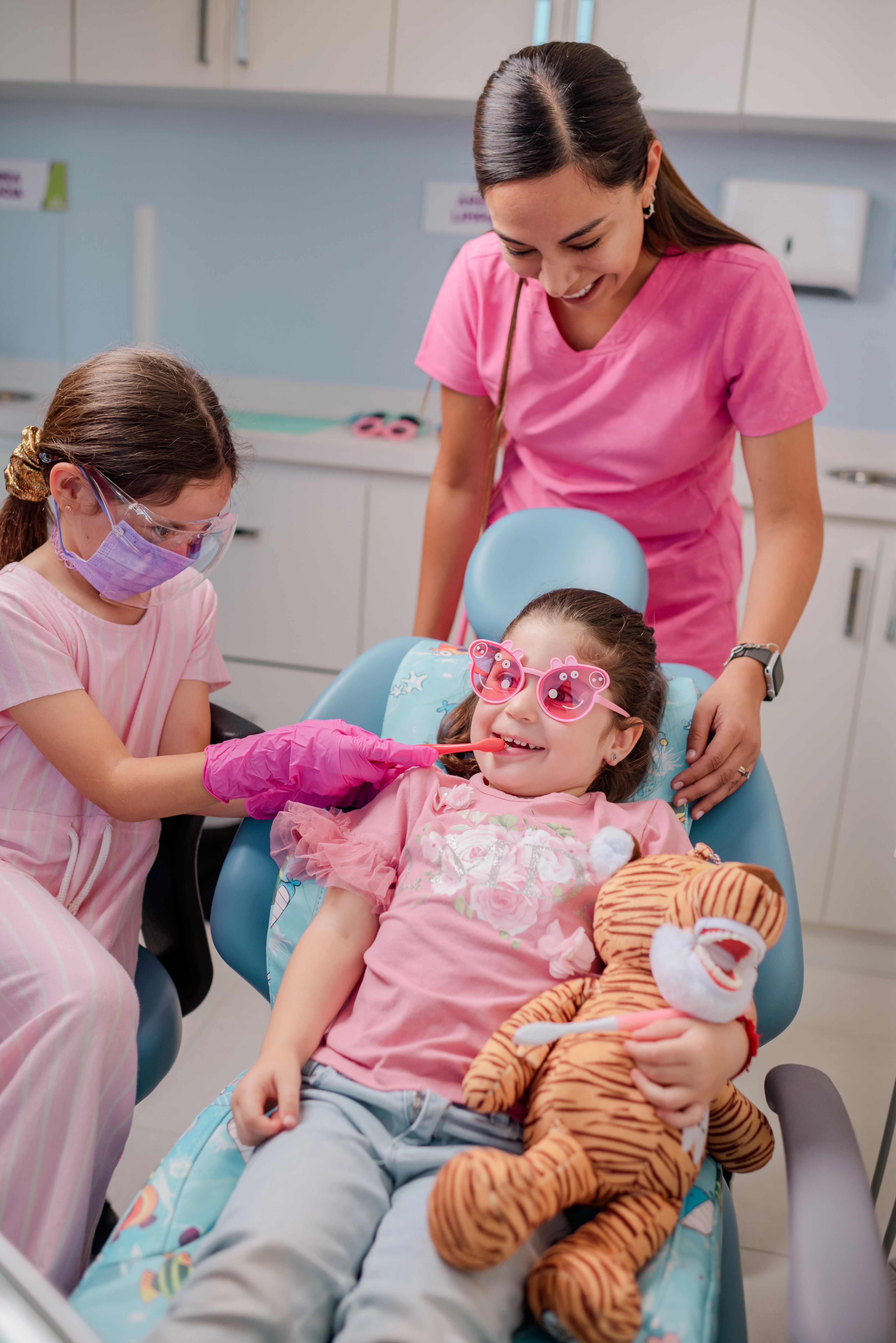 Niña tranquila en el sillón de Dentikid, acompañada por el equipo