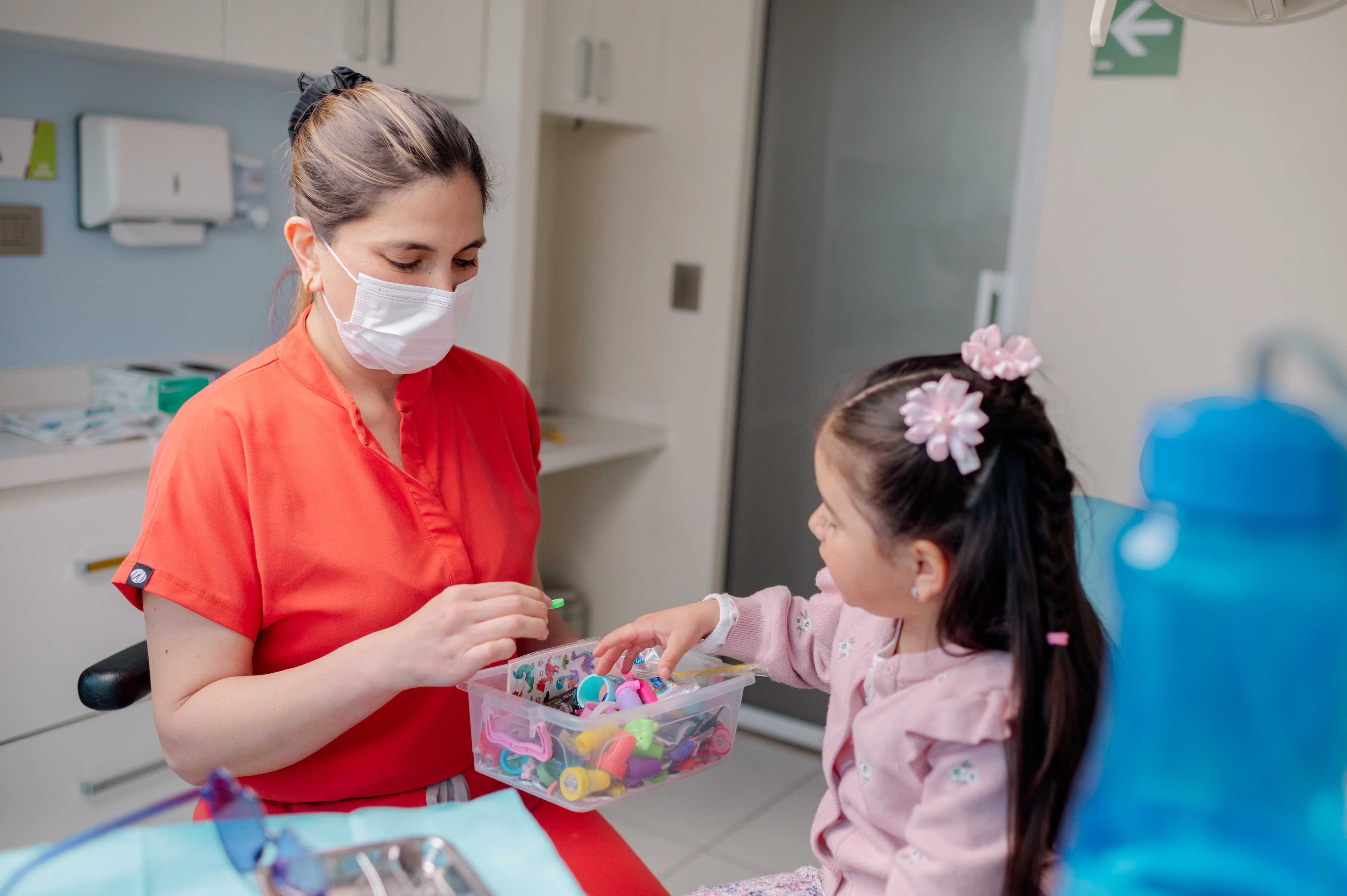 Odontopediatra de Dentikid mostrando un modelo dental a una niña