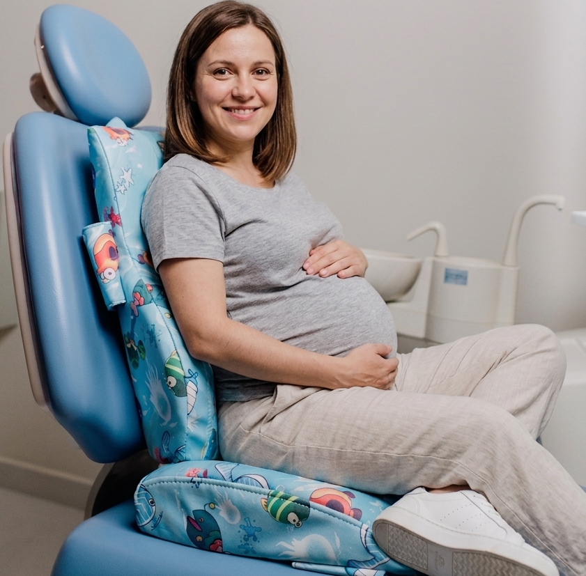 Mujer embarazada sonriente sentada en el sillón dental de Dentikid durante un control odontológico prenatal