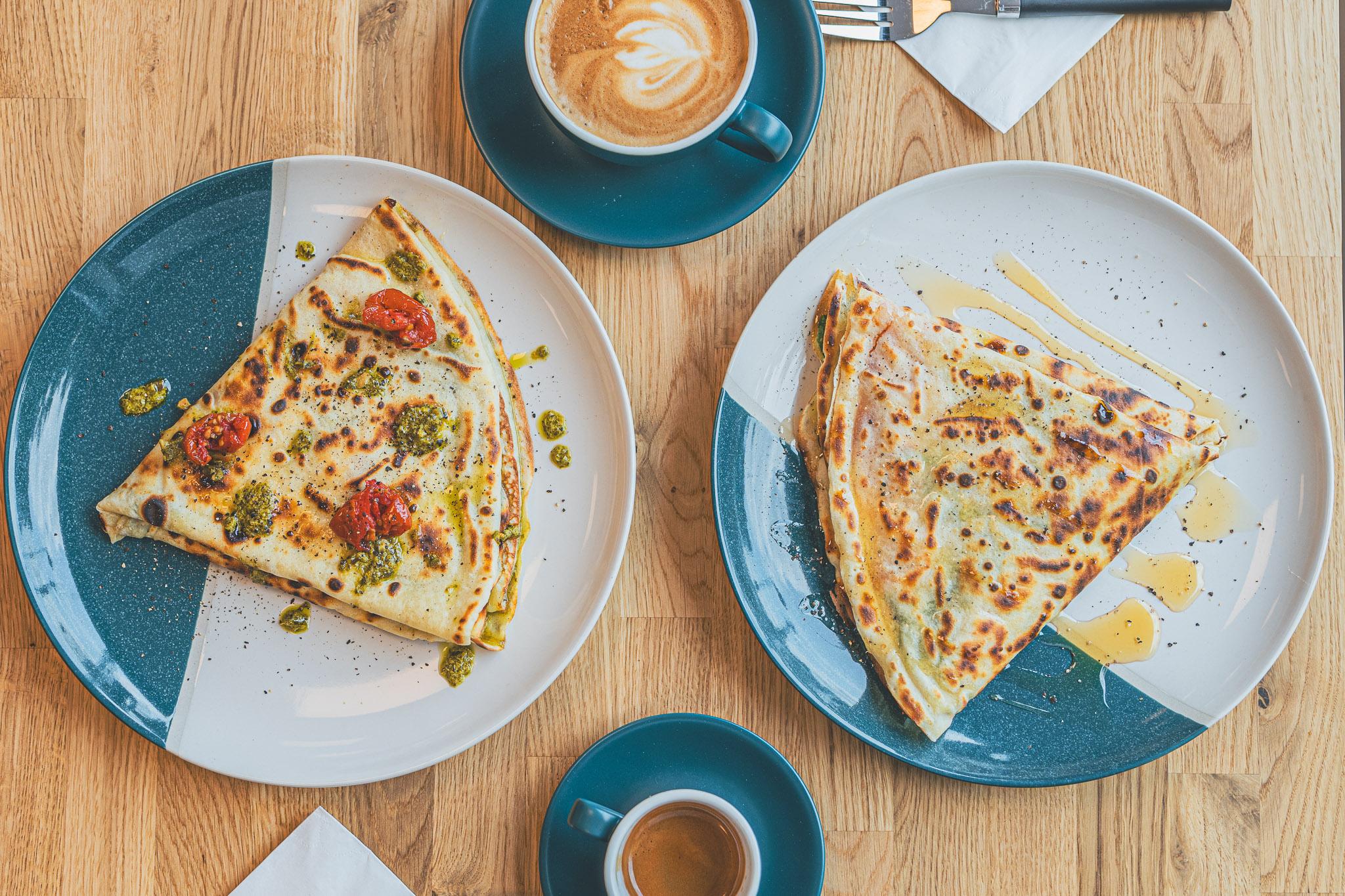 Two savoury crepes with coffees, seen from above