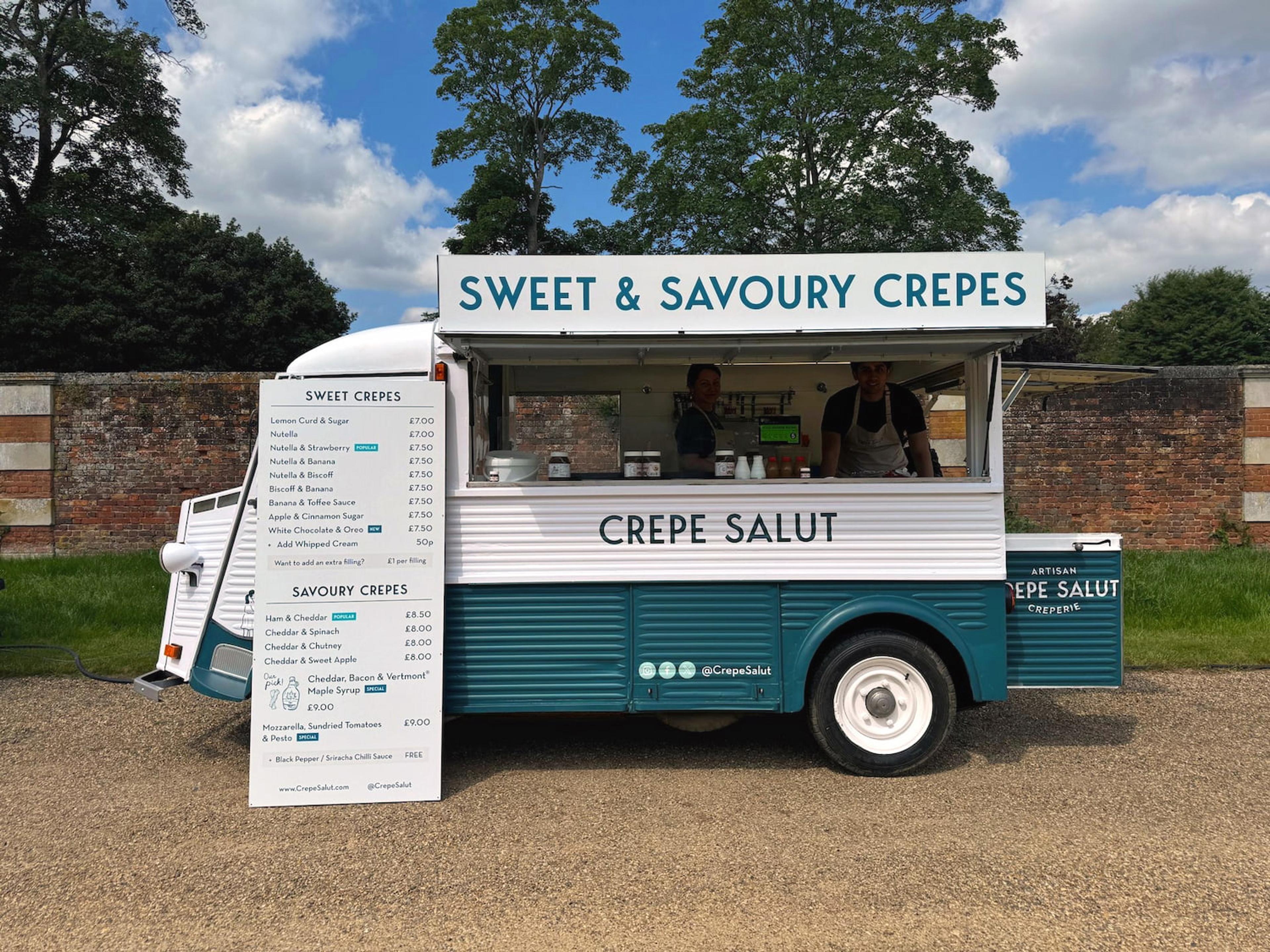 The Crepe Salut van set up beside a brick garden wall