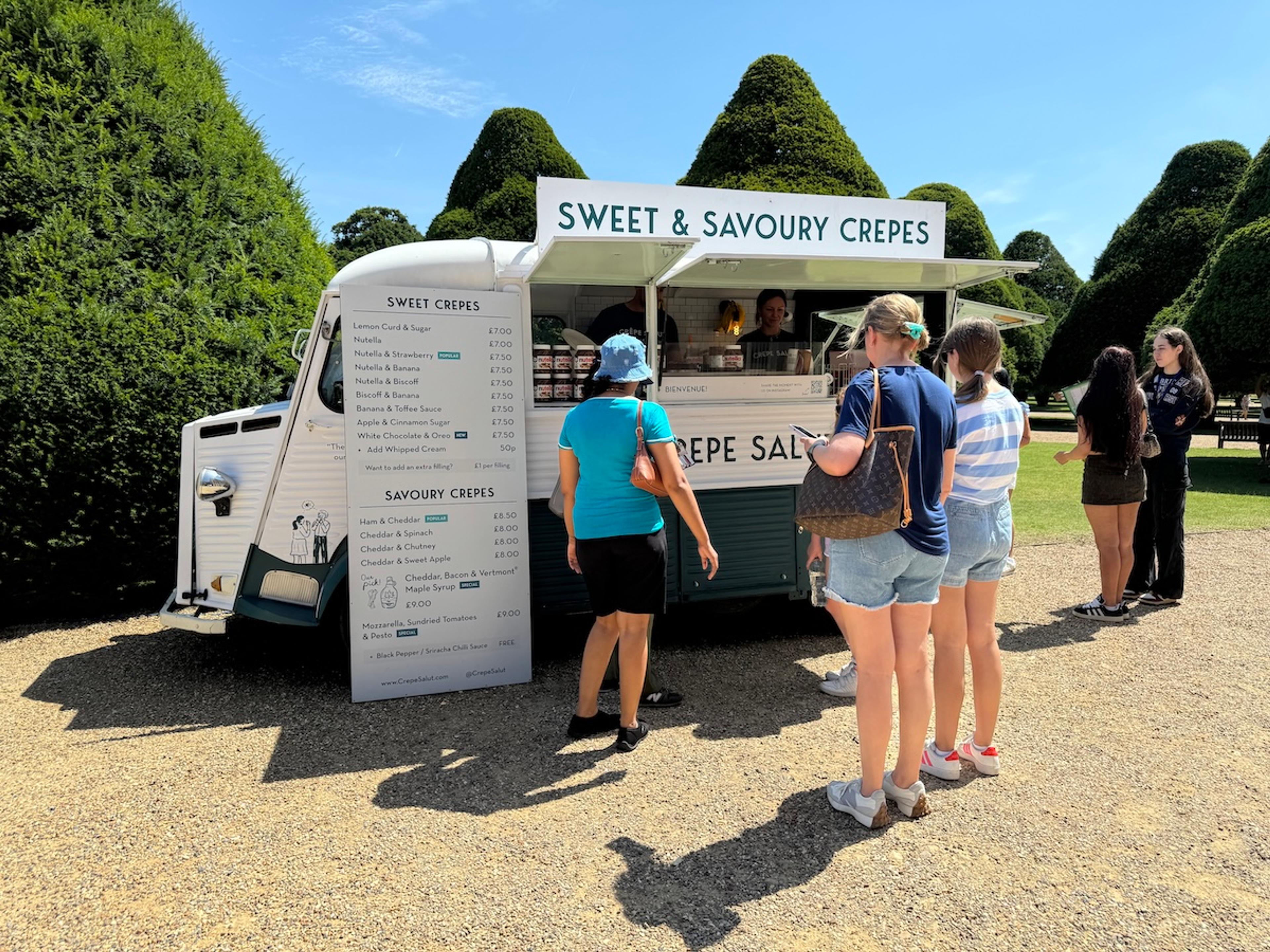 A queue at the crepe van beside topiary gardens