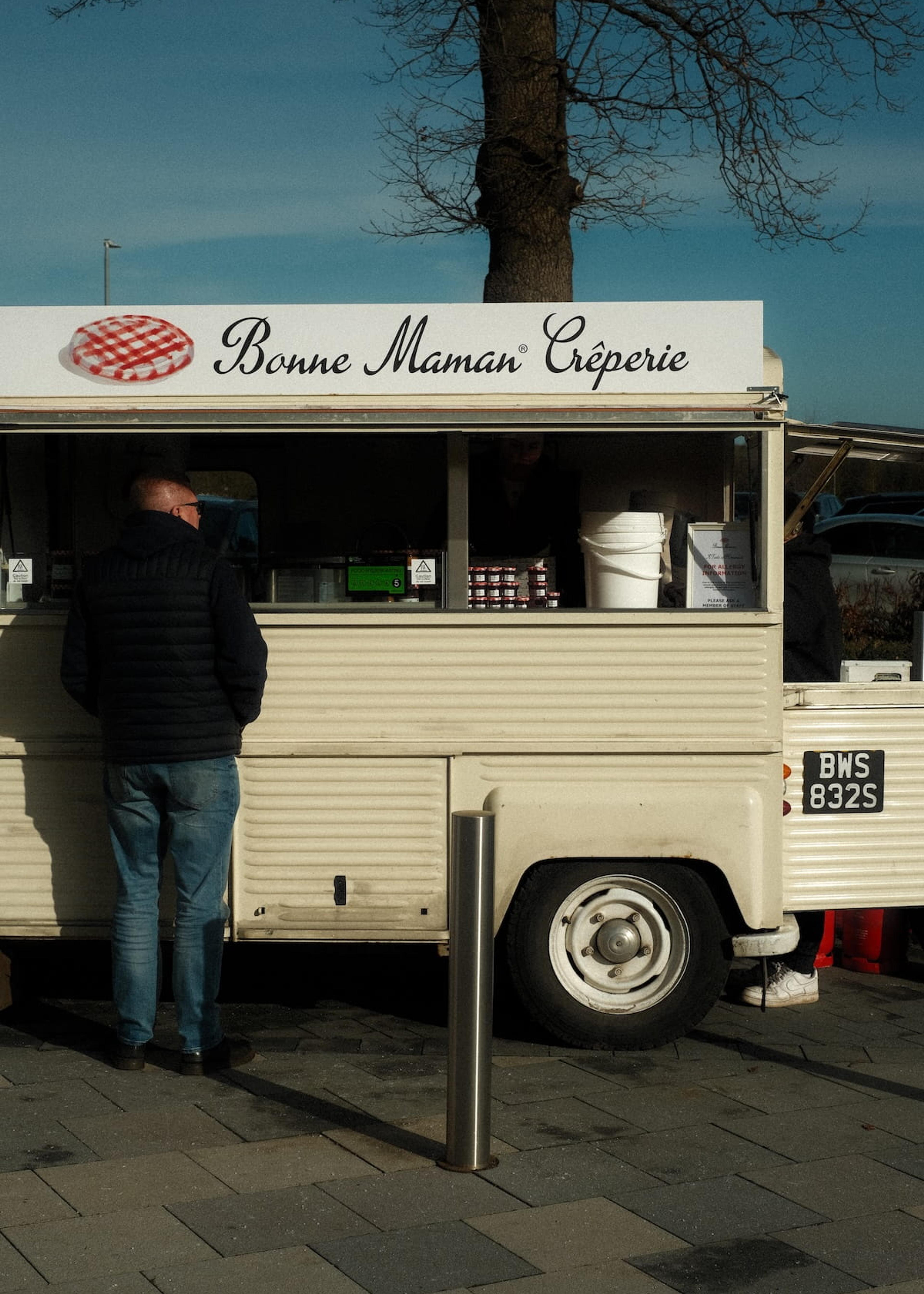 A customer at the white-label Bonne Maman Creperie van