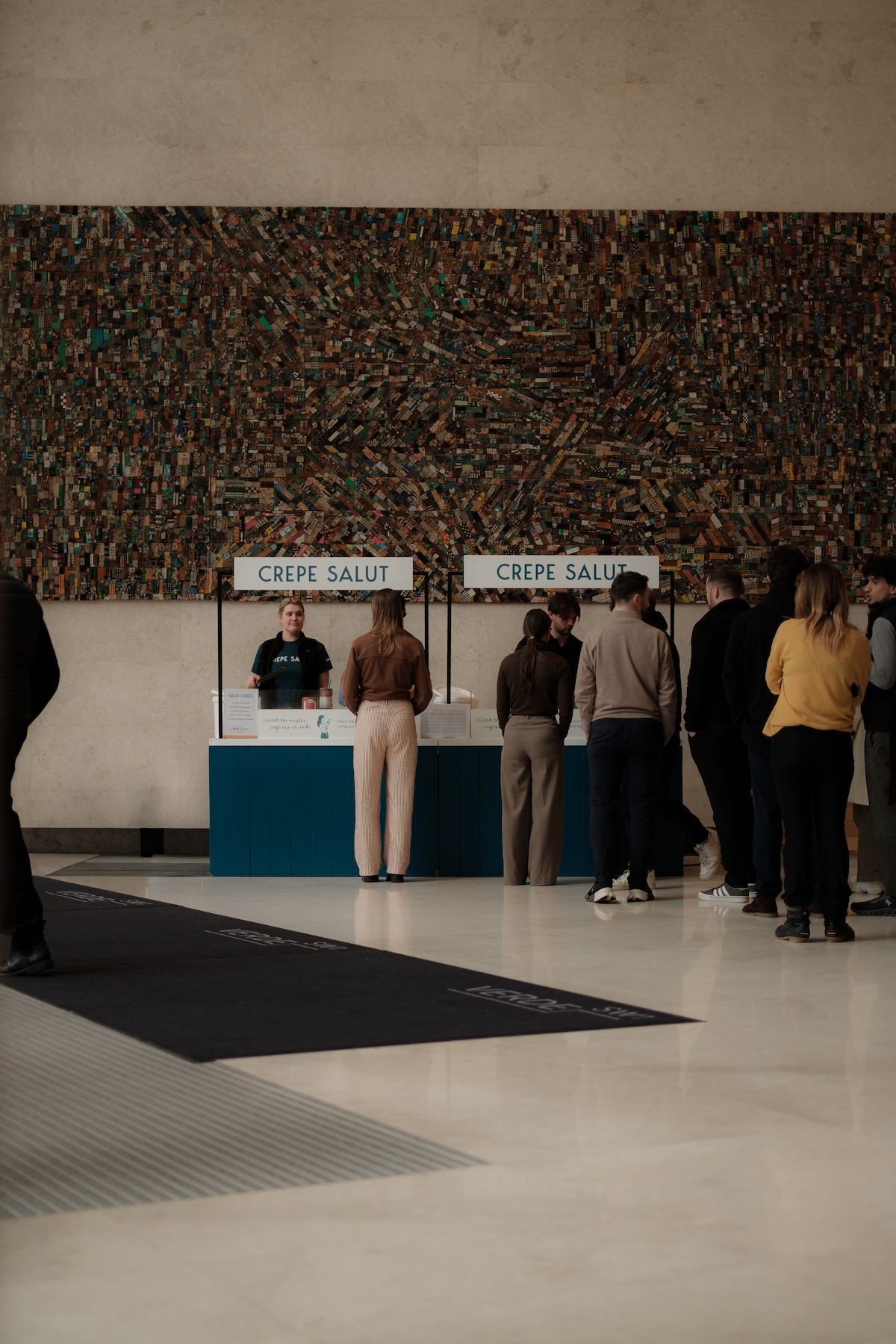 Guests queuing at two branded counters in a lobby