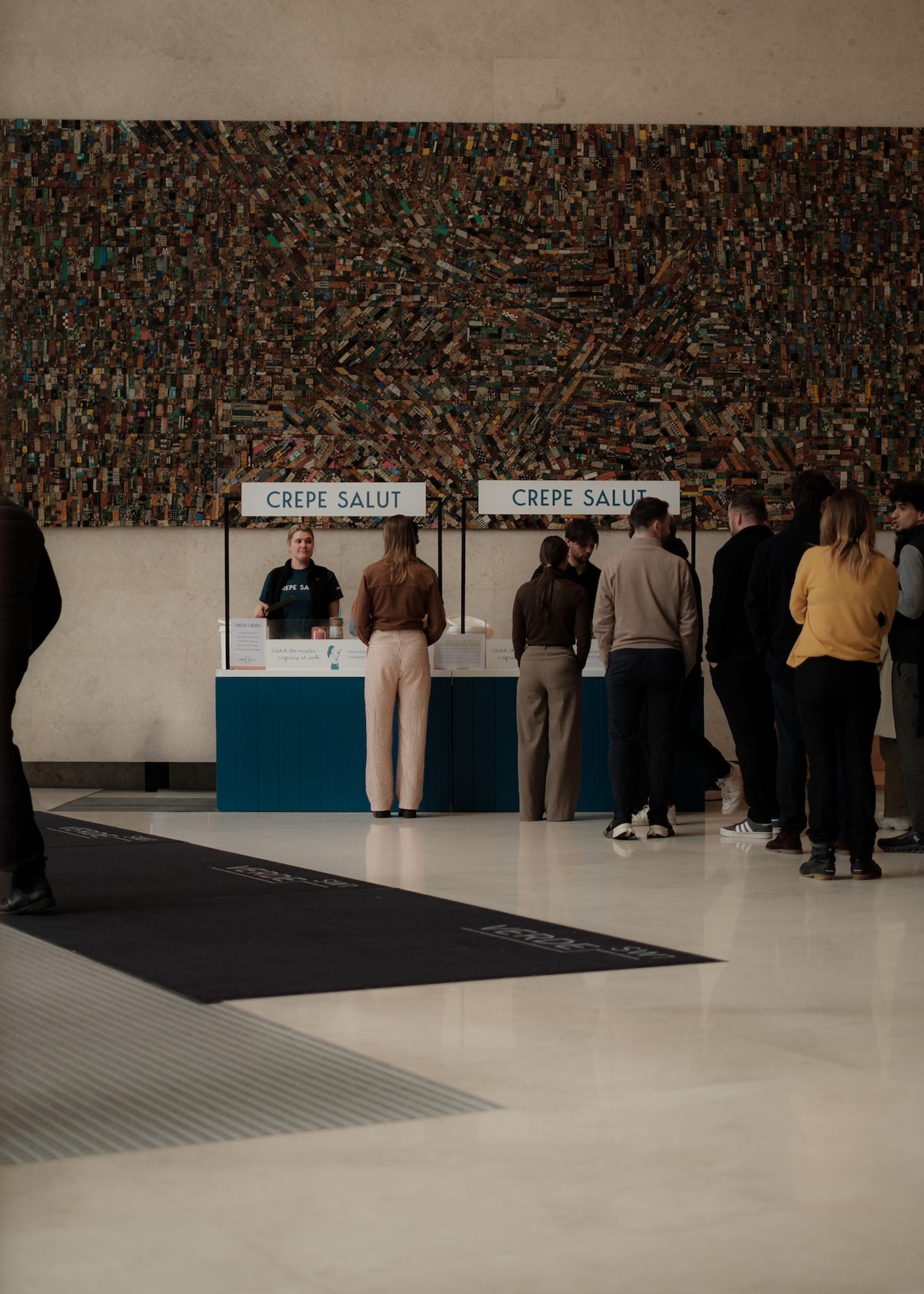 Guests queuing at two branded counters in a lobby