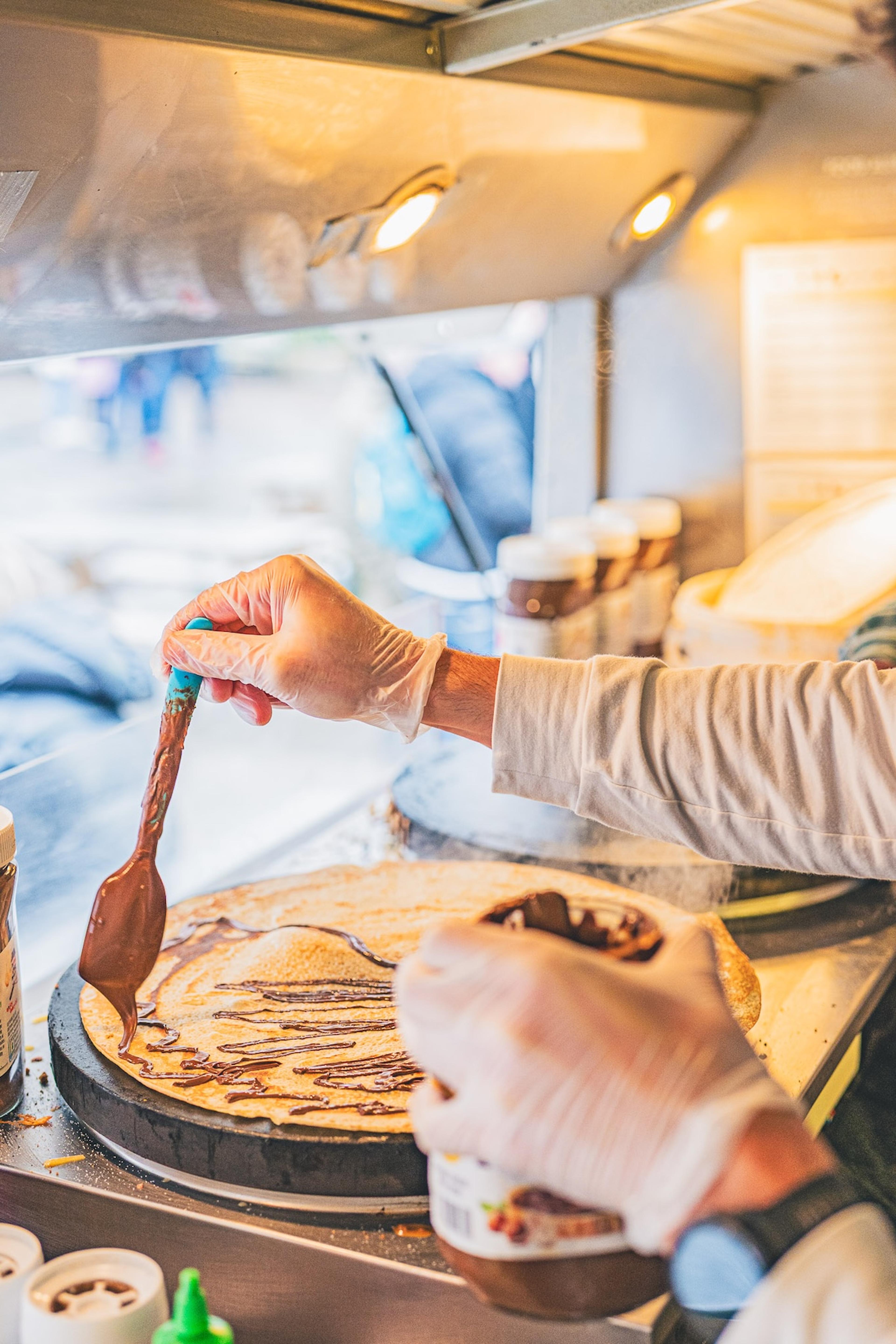 Spreading Nutella on a crepe in the van