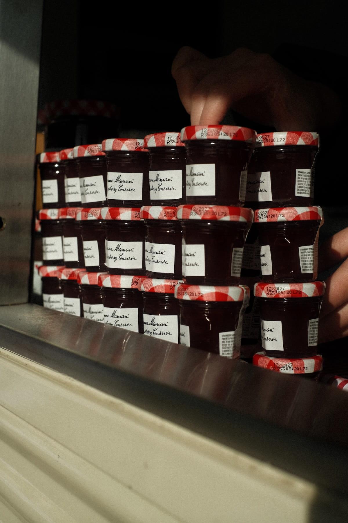 Mini jars of Bonne Maman strawberry conserve stacked in the van hatch