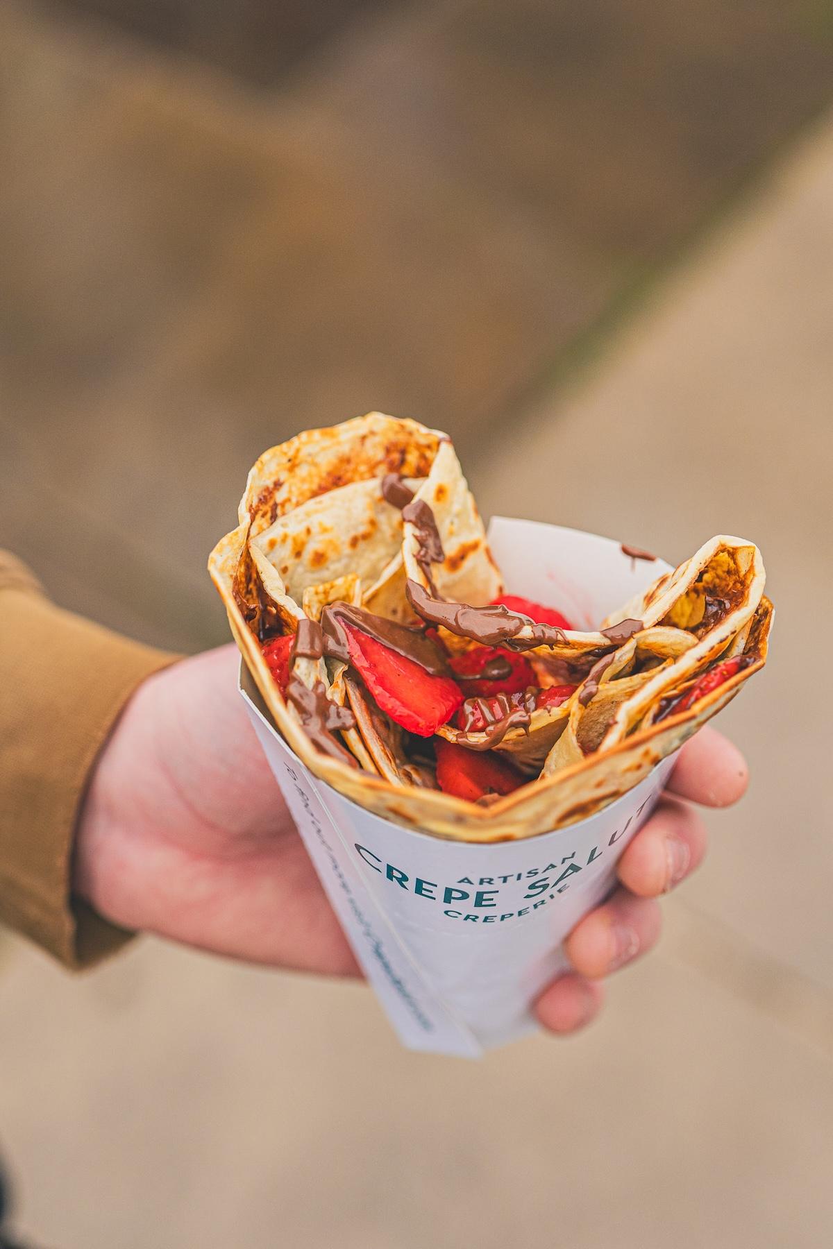 A Nutella and strawberry crepe in a branded cone