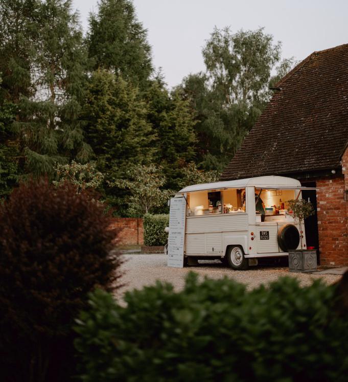 The crepe van lit up at dusk outside a venue barn