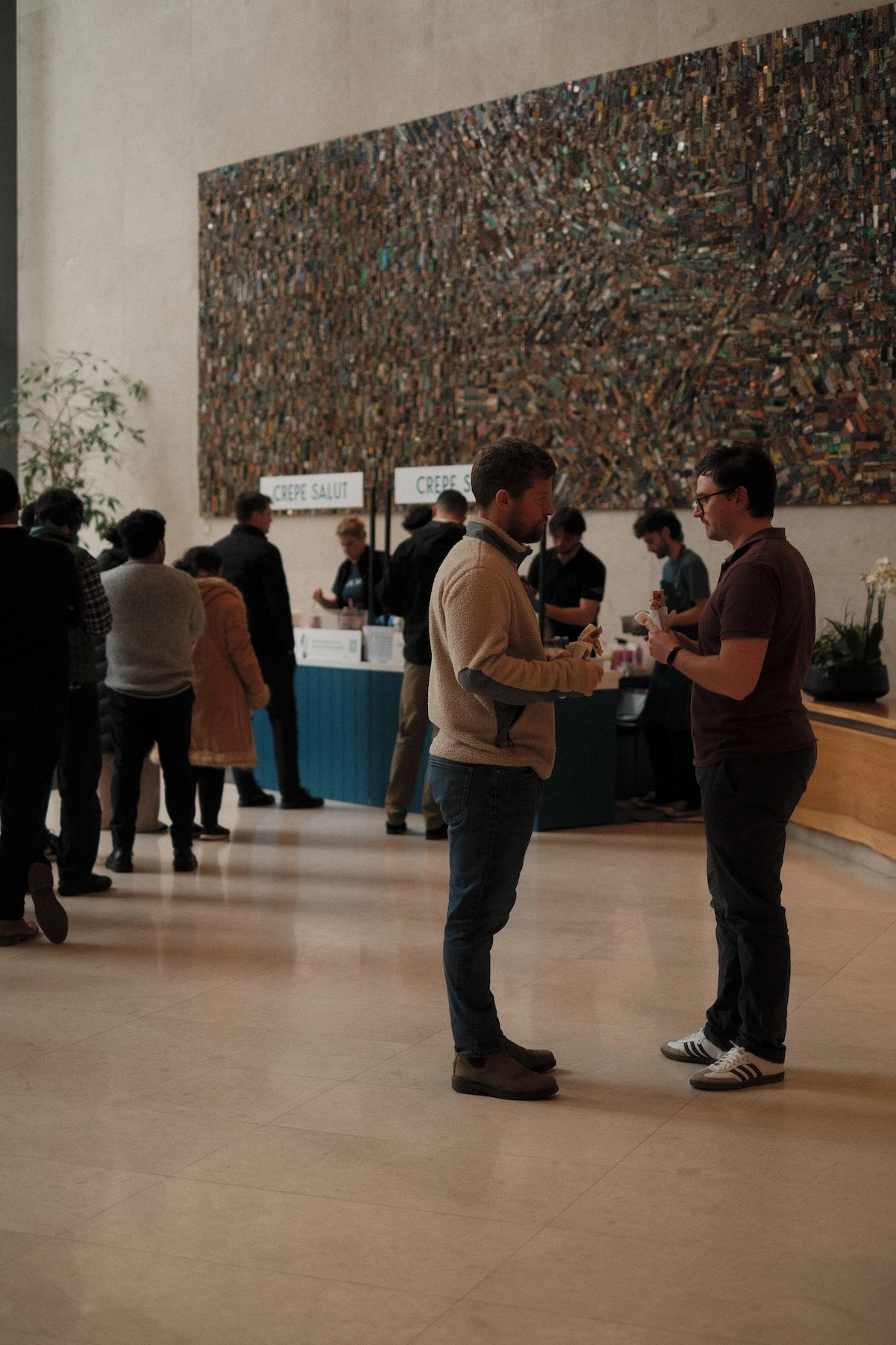 Guests chatting in front of the Crepe Salut counter in a lobby