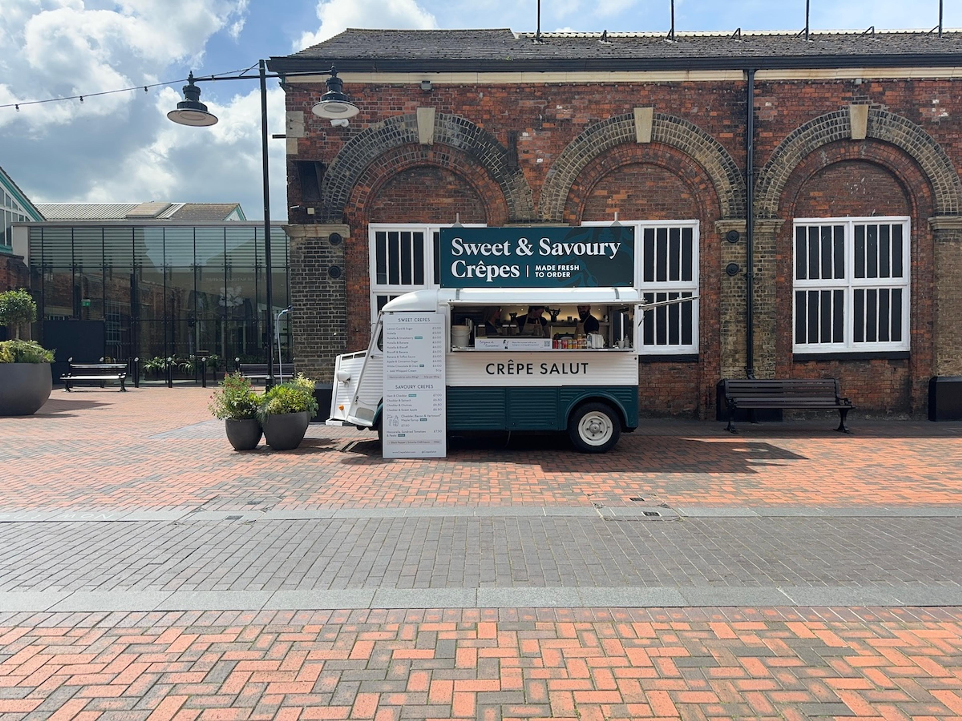 The crepe van outside a brick warehouse building