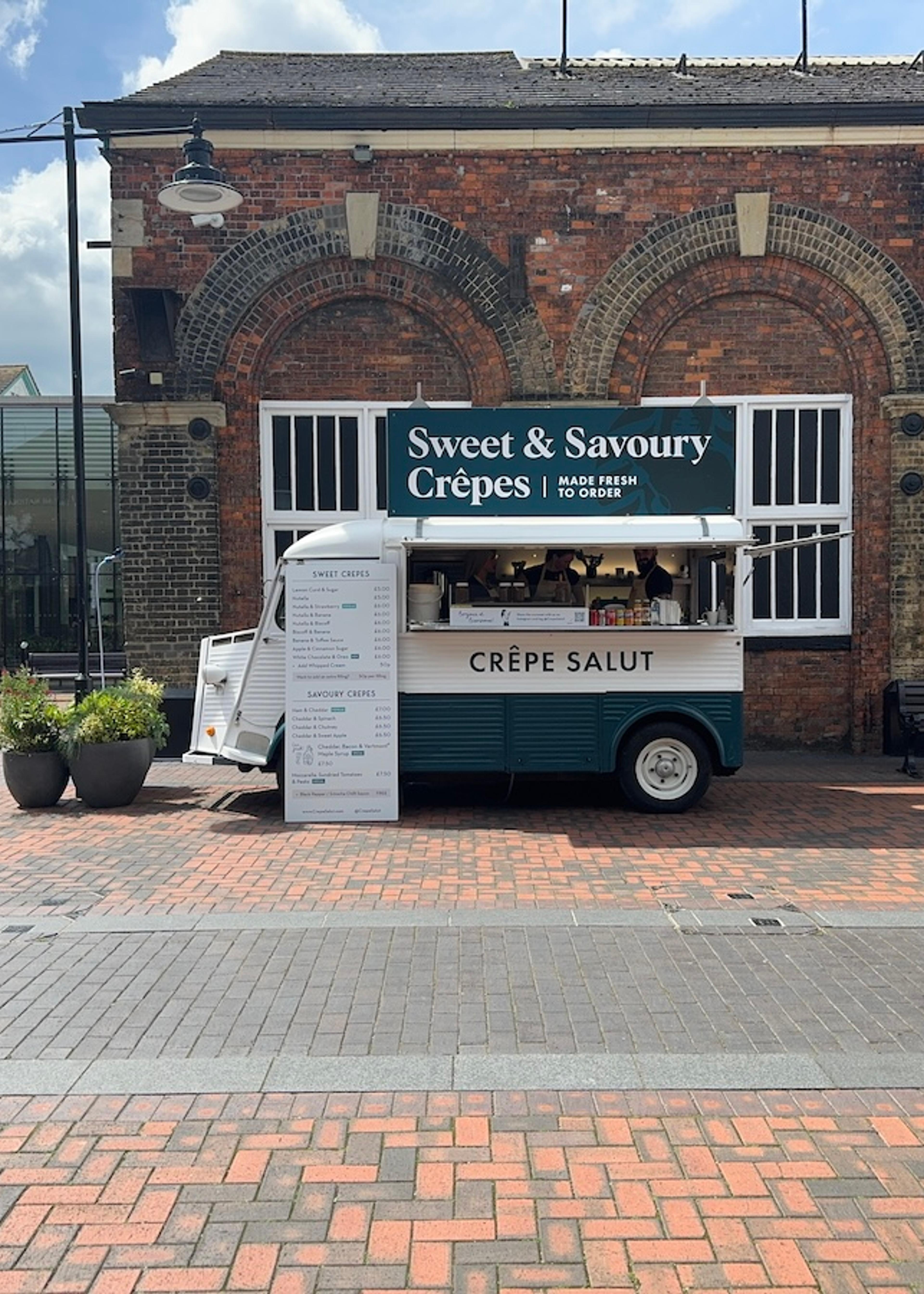 The crepe van outside a brick warehouse building