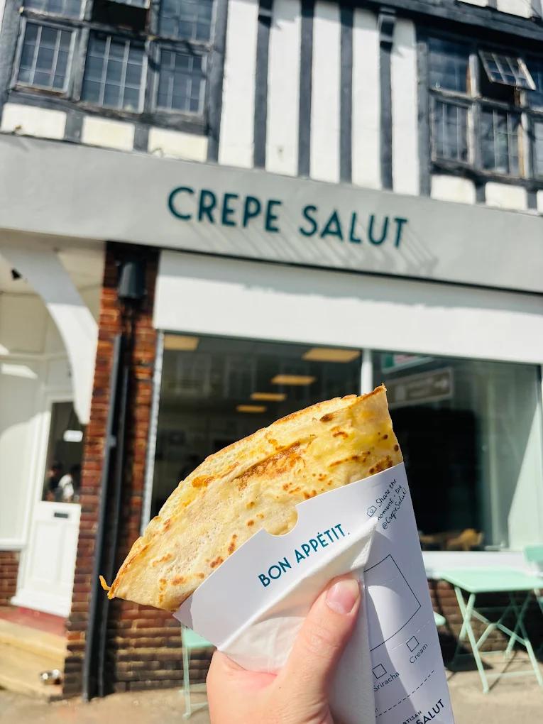 A crepe in its paper sleeve outside the Cheam creperie