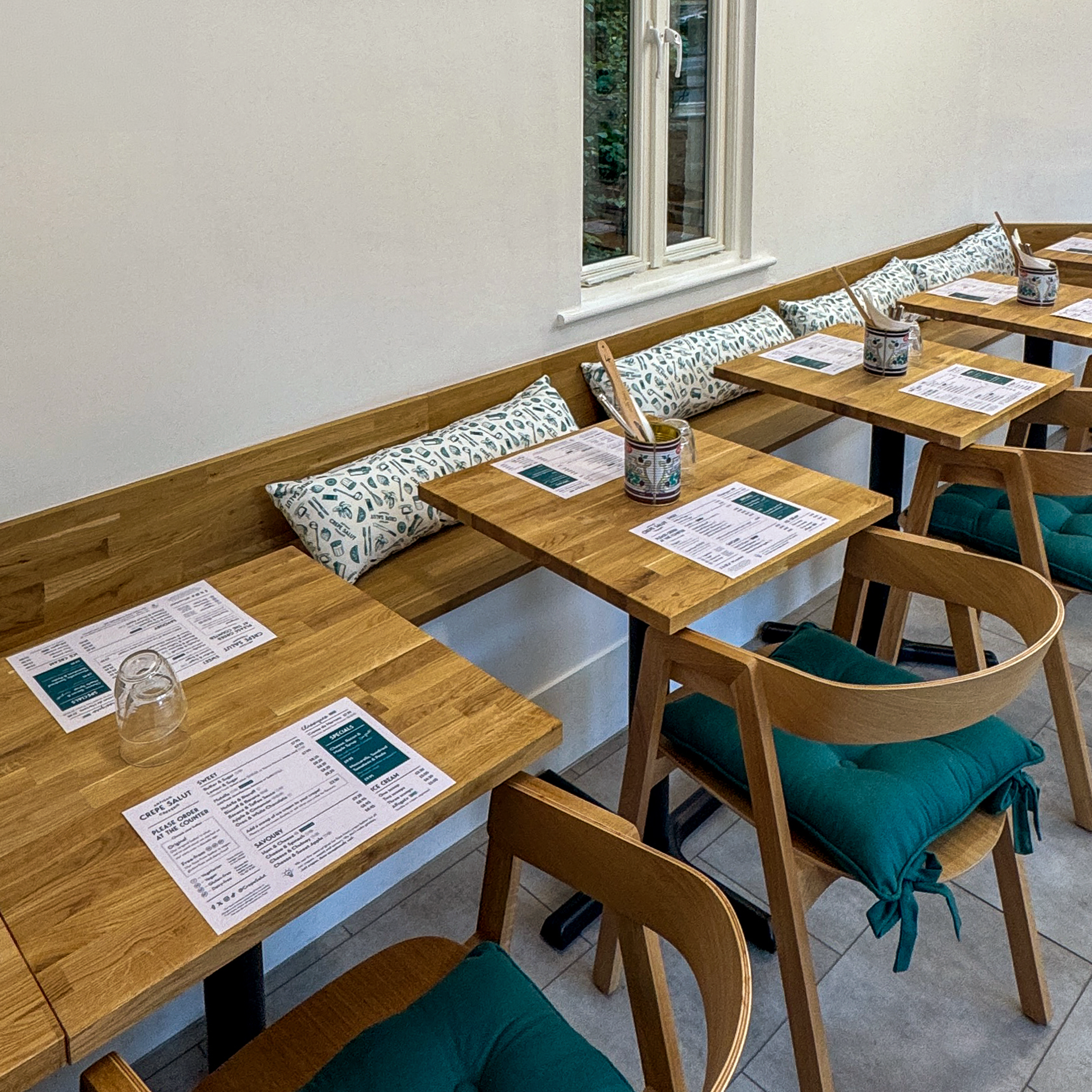 Tables set with menus inside the creperie