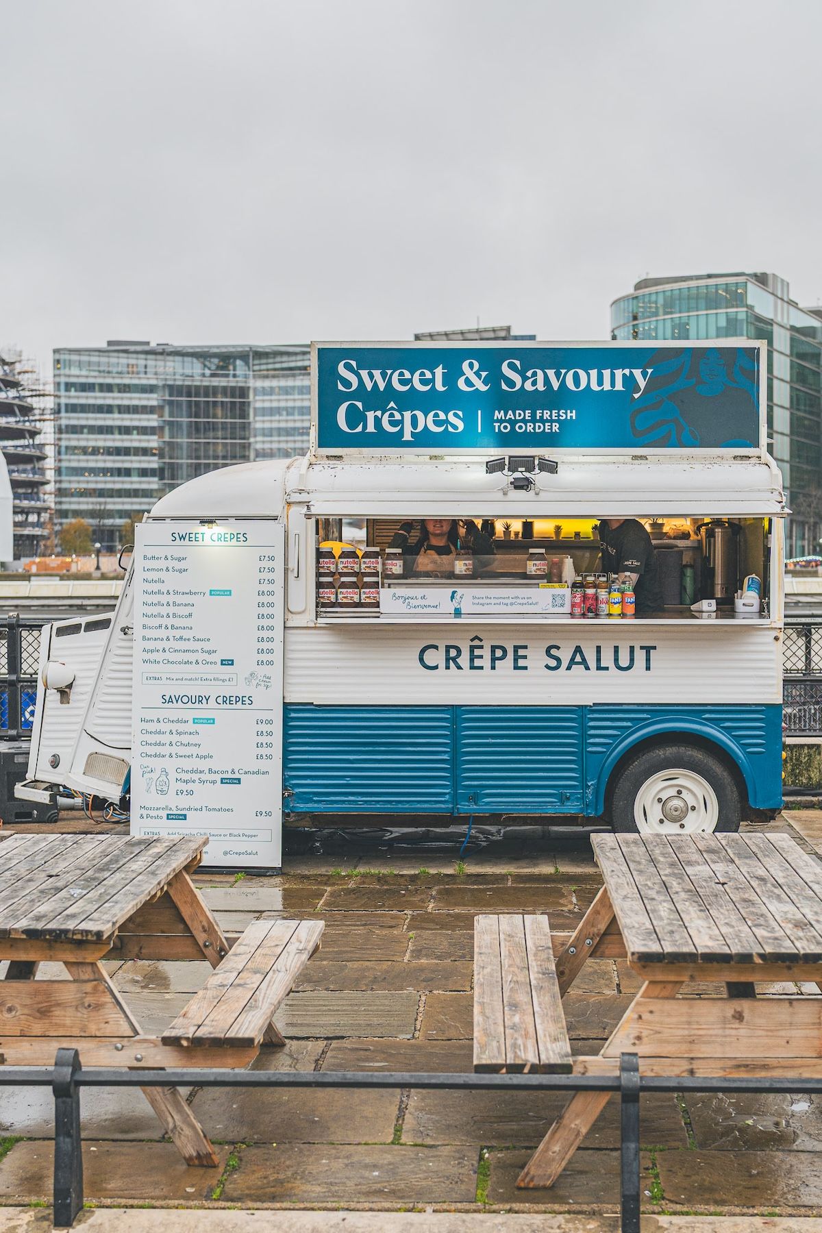 The crepe van pitched with picnic benches by the river
