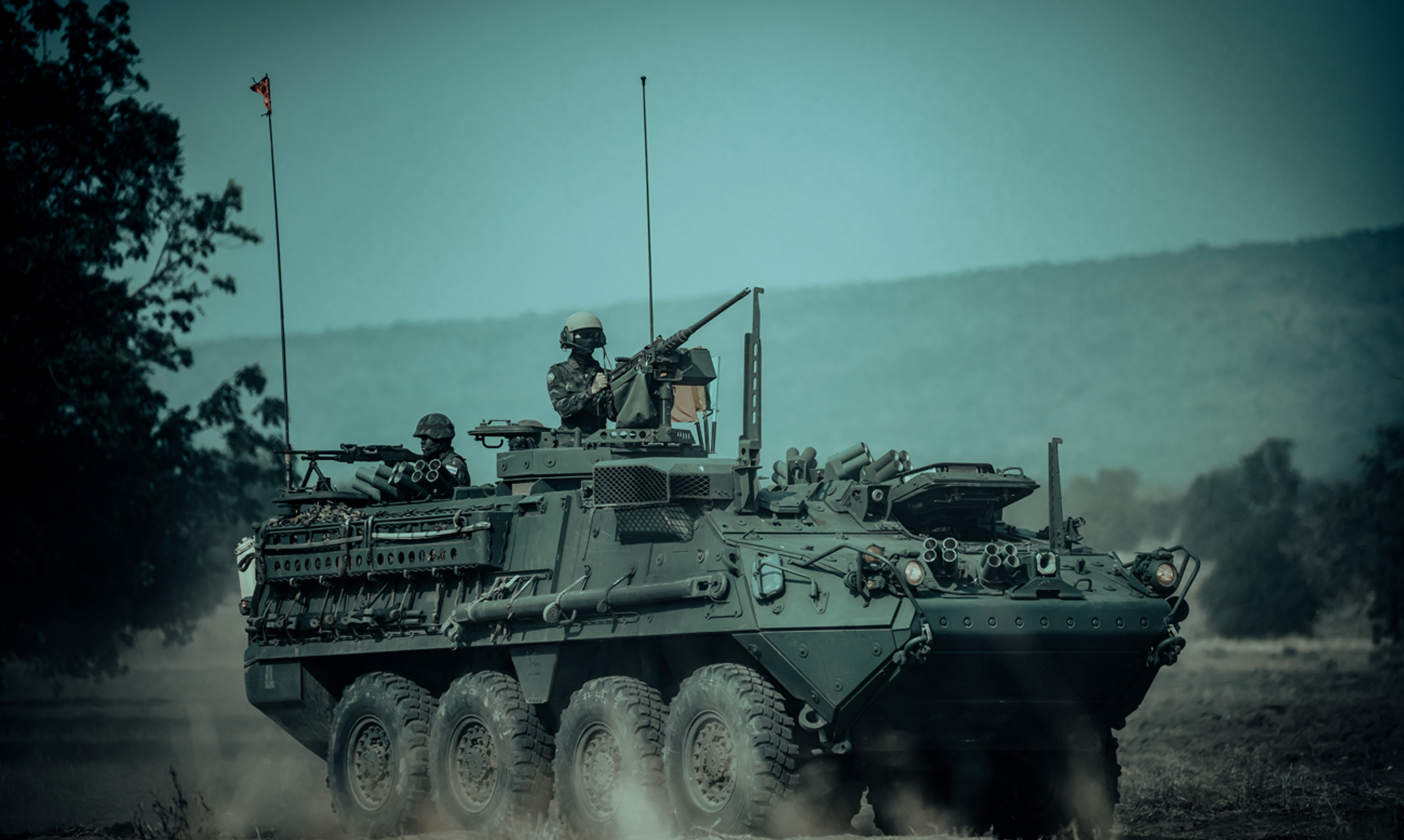 Stryker armoured fighting vehicle advancing across open ground