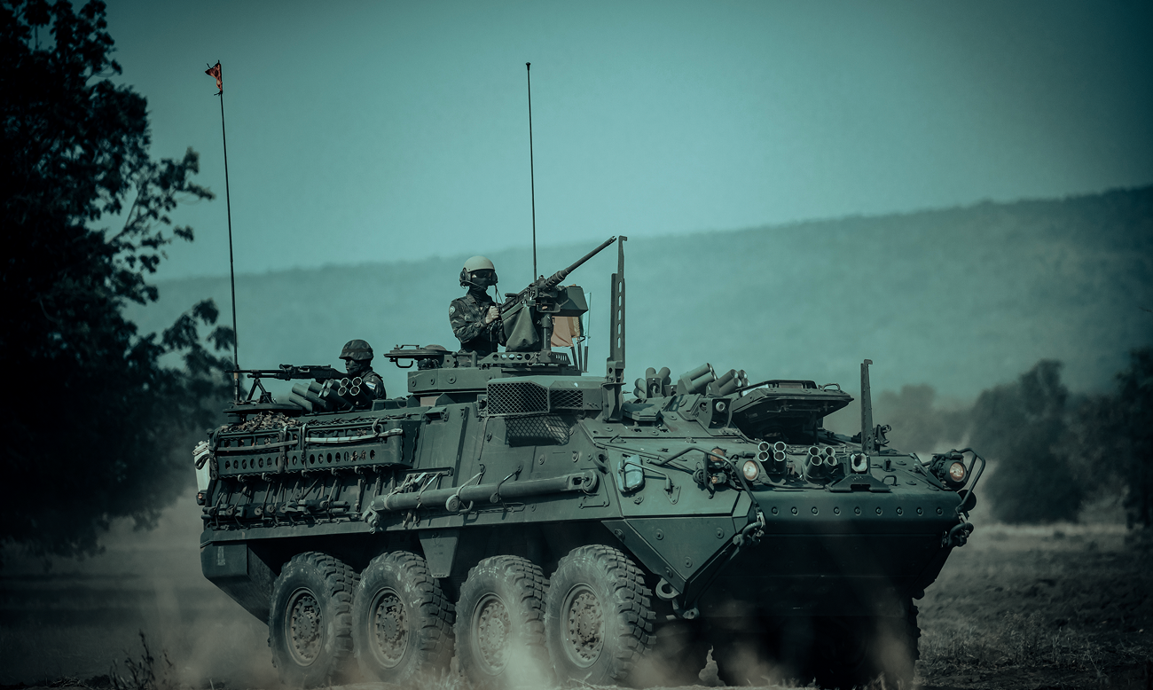 Stryker armoured fighting vehicle advancing across open ground
