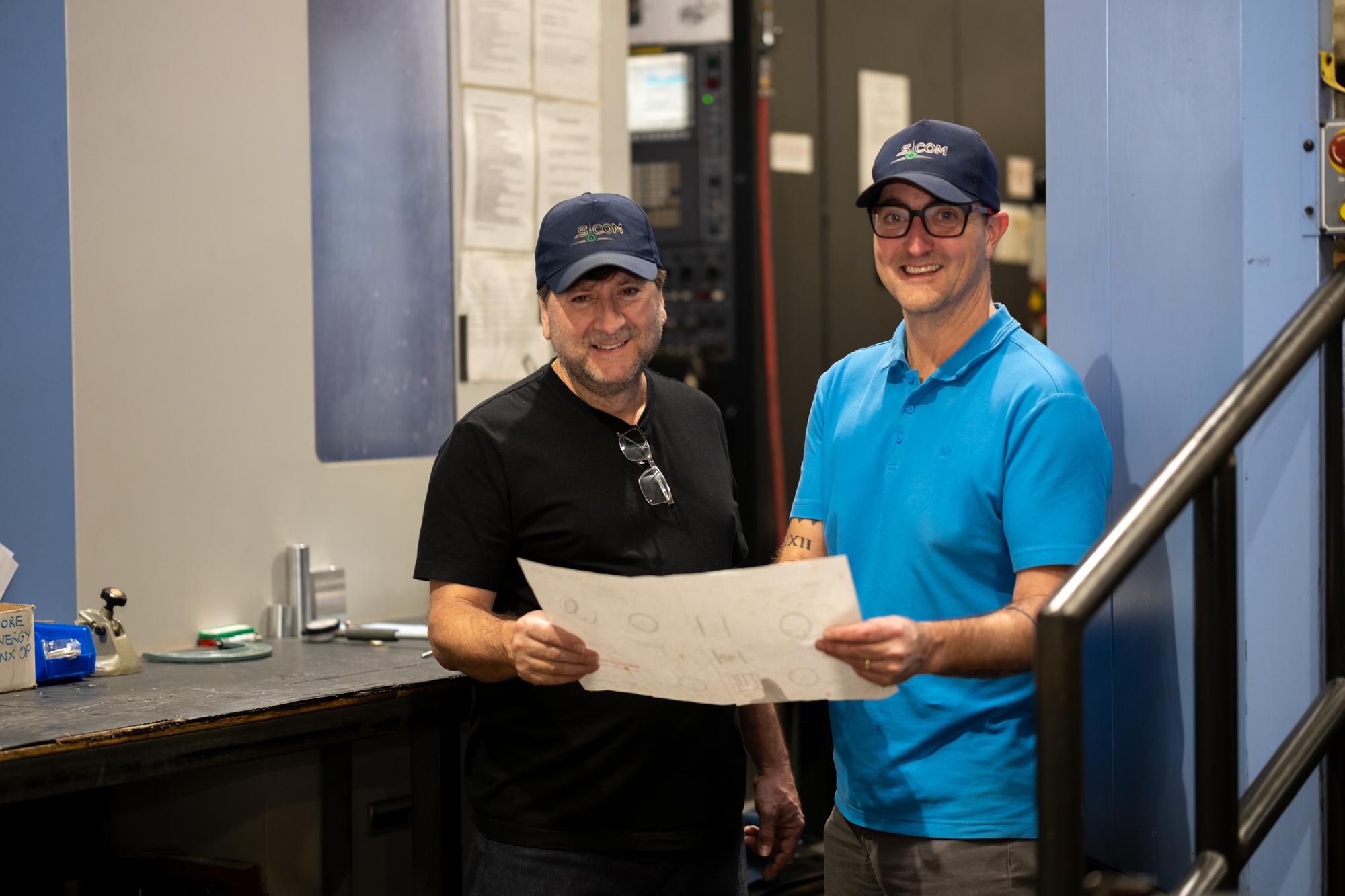 Quality inspector examining a machined cylindrical component at a coordinate measuring machine