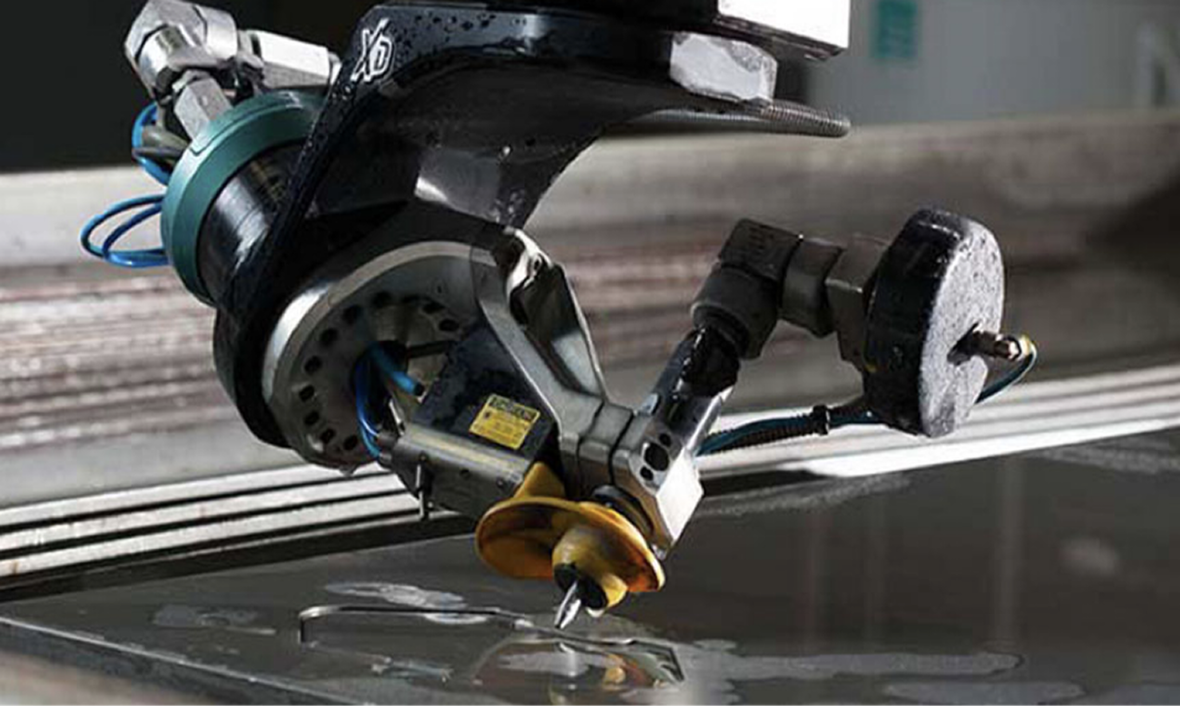 Five-axis waterjet cutting head trimming a sheet of material