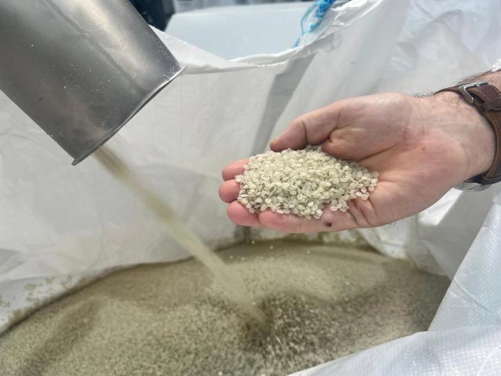 Hand holding reprocessed polyproplyne pellets