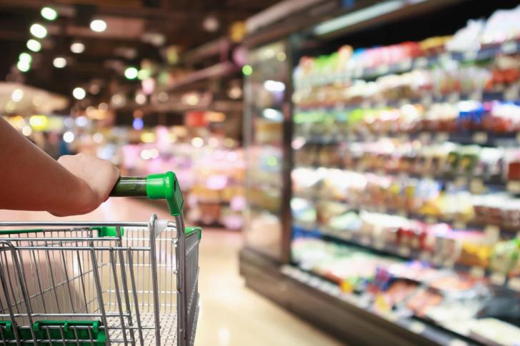 Image of a supermarket trolley in front of supermarket shelves