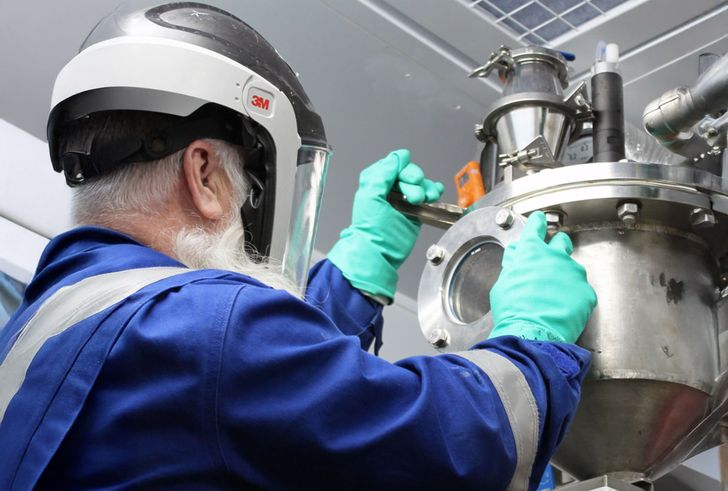 Person working on mechanical tubes that are part of chemical recycling pilot plant