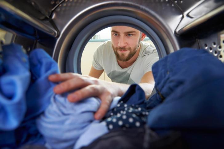 Clothes being taken out of a washing machine, from inside the washing machine
