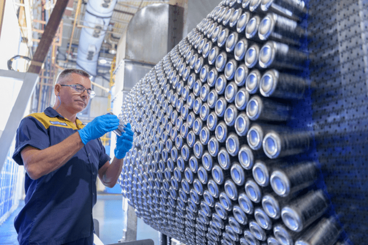 Employee next to aluminium cans