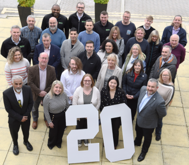REPIC Team pictured outdoors with large number 20 to celebrate 20 years