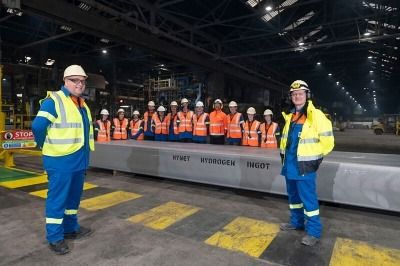 Novelis team in front of aluminium ingot made using hydrogen fuelled power