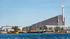 Incineration plant in the district of Amager, Copenhagen, Denmark, with modern buildings and boats